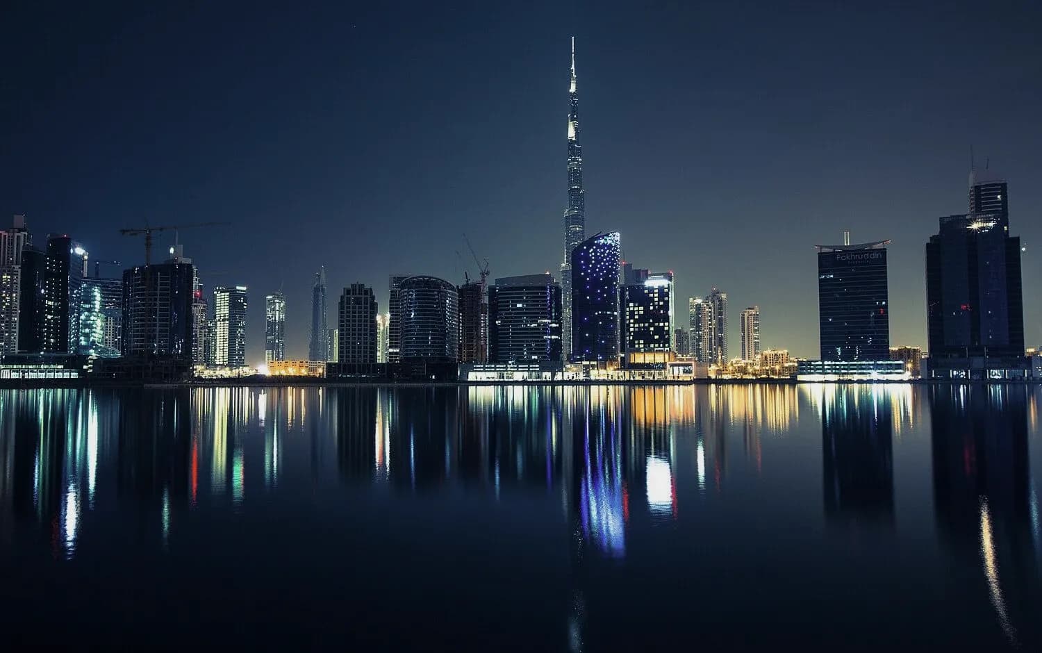 Downtown Dubai skyline reflected in the water at night